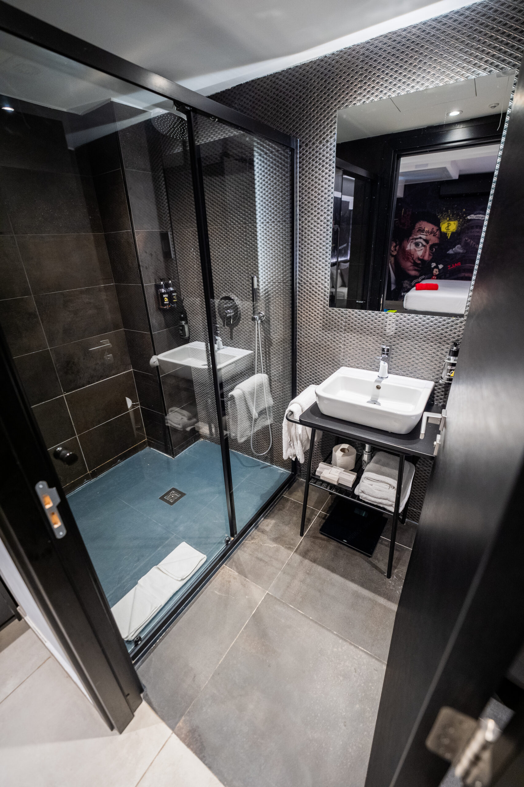 Modern bathroom with walk-in shower and dark tile finishes